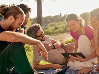  A group of young people sit together in a park and discuss