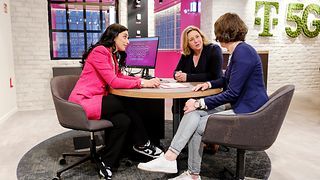 drei Menschen unterhalten sich sitzend am Tisch